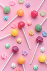 Sweet lollipops and candies on pink background