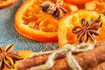 Fototapeta na wymiar Slices of dried oranges or tangerines with anise and cinnamon, on a blue background. Vegetarianism and healthy eating