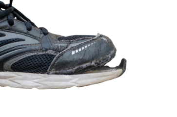 side view broken old black canvas shoes on transparent background