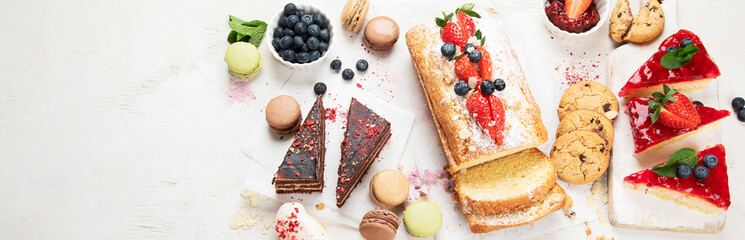 Table with various cookies, cakes and fruits. Delicious dessert table.