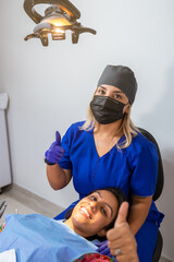 Smiling Dentist and Patient During Dental Procedure in Her Office