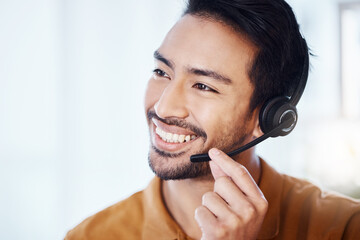 Asian man, call center and smile with headphones for customer service, consulting or support at...