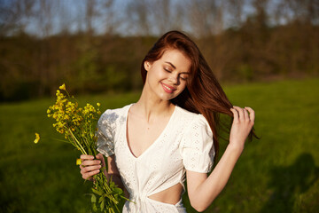 portrait of a happy woman with a bouquet of buttercups walking in the field