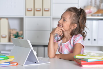 Portrait of beautiful little girl with tablet pc