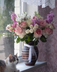 Splendid bouquet of flowers on a windowsill and cat
