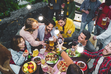 Outdoor Friends Gathering - Aerial view of a diverse group of friends enjoying a sunny outdoor brunch, laughing and bonding over food and drinks.