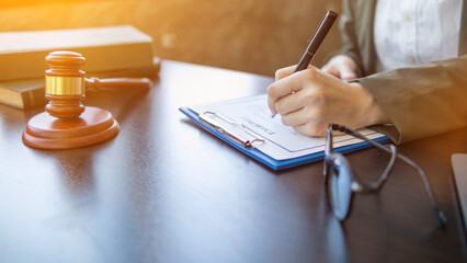 Lawyer holding contract documents in hand and preparing to sign a consulting contract for a team of business people who need legal advice to run their business in accordance with the law