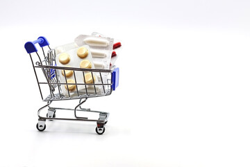 Shopping cart with medicines. Concept of health and pharmaceutical expenditure, medicine and health care. Space for text