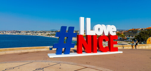 I love Nice sign at Quai Rauba Capeu seashore promenade below Colline du Chateau Castle Hill at French Riviera of Mediterranean Sea in Nice in France - 594889283