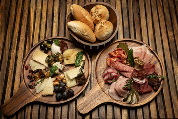 mixed charcuterie and cheese cold cuts platter on wood table