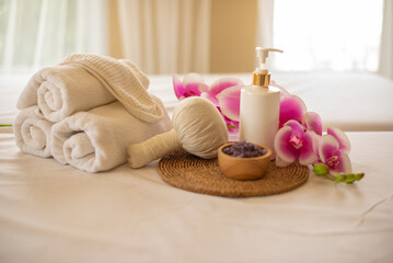 The carefully arranged composition of the compress ball spa salt cup, and lotion bottle creates an...