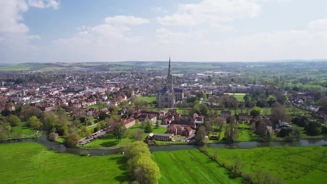 Long distance aerial tracking shot of salisbury Cathedral and surroundings on sunny day