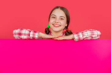 happy child behind pink paper with copy space for advertisement