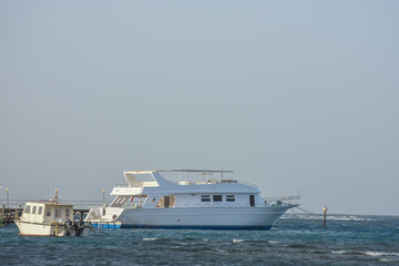 white boats on a jetty in the red sea with blue sky detail