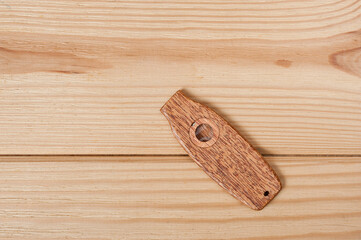Kazoo is a musical wind instrument made of wood, filmed on a wooden surface.