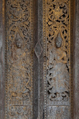 Fototapeta na wymiar Patterns of angels carved from wooden on the church door of Wat Pa Ruak, which is an abandoned temple. Located at the way up Mount Phousi. AT Central Luang Prabang city in Northern of Laos.