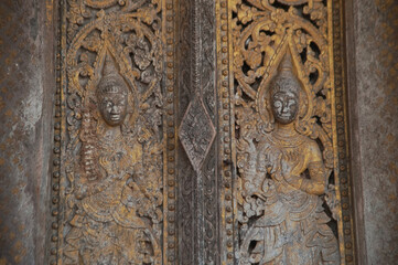 Patterns of angels carved from wooden on the church door of Wat Pa Ruak, which is an abandoned temple. Located at the way up Mount Phousi. AT Central Luang Prabang city in Northern of Laos.