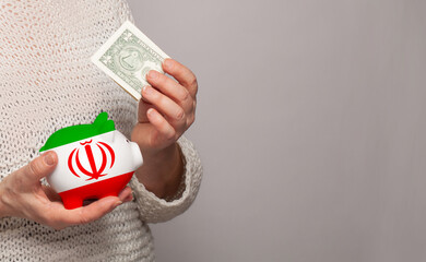 Flag of Iran on money bank in Irani woman hands. Dotations, pension fund, poverty, wealth, retirement concept