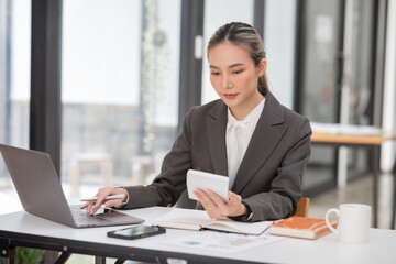 Young Asian businesswoman working on documents at office