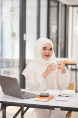 Young islamic Asian businesswoman holding notebook about business, spending money
