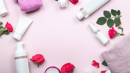Composition with cosmetic products and roses flowers on pink background.
