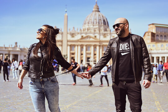 Happy smiling beautiful  Tourists  couple traveling at Rome, Italy, poses and making photos  in front of   Vatican City  at, Rome, Italy.Concept of Italian gastronomy and travel. Italian couple having