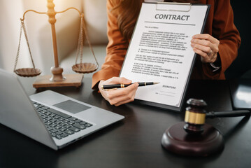 Judge gavel with scales of justice, Business and lawyer or counselor consulting and discussing contract papers with laptop and tablet at law firm