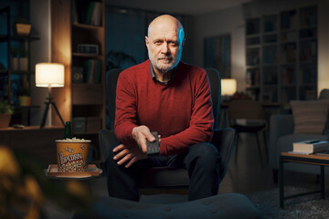 Relaxed senior man watching TV at home