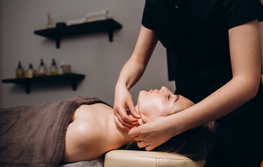 Face massage. Close-up of young woman getting spa massage treatment at beauty spa salon.Spa skin and body care. Facial beauty treatment.Cosmetology