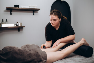 Massage for feet. In massage salon. Asian female esthetician vacuuming with machine at salon