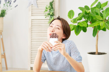 自宅で板チョコを食べる女性