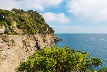 Rocky coast and Mediterranean Sea (Ligurian Sea) in front of Portofino village. Luxury tourist resort in Genoa Province (Genova), Liguria, Italy, Europe.