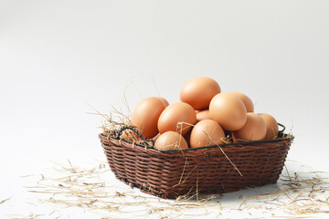 Fresh eggs in a basket laying on a white background
