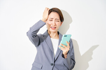 スマートフォンを持って困るビジネスウーマン　白背景