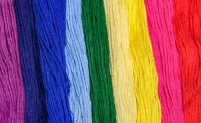 Kolorowe nici wypełniające cały kadr tworząc motyw tęczy 