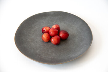 Fresh ripe cherries in a gray plate on a white background. Healthy food. Vegetarian breakfast. Close-up