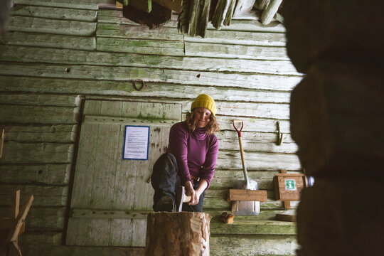 Woman chopping wood in shed