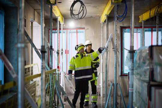 Male and female engineer working at construction site