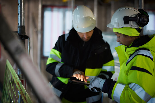 Male and female engineer working at construction site