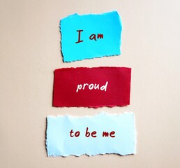 Torn paper with handwriting  I AM PROUD TO BE ME, positive  mantra affirmation message to boost self esteem, self acceptance and self compassion
