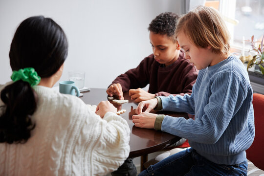 Girl and boys playing scrabble at dining table