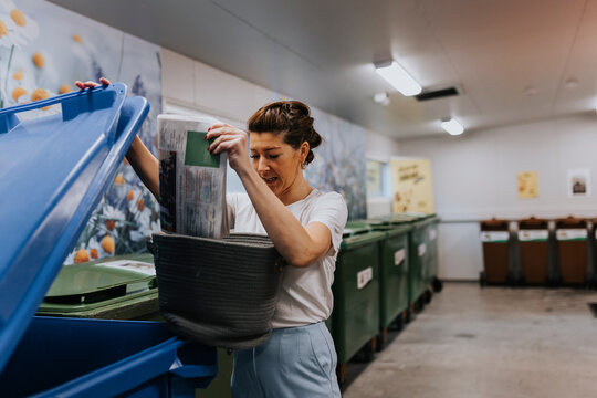 Smiling woman putting recycling into bins