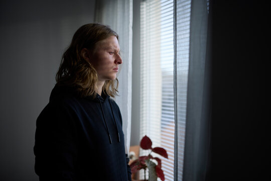 Sad man looking through window