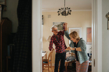 Senior couple dancing at home