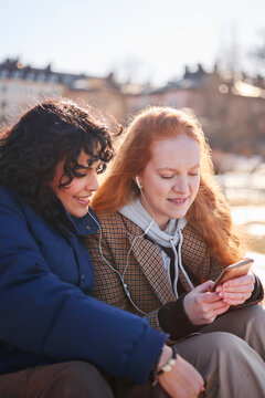 Young women listening to music from smart phone