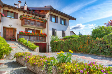 Awesome View of Traditional alpine houses with flowers on balcony the Cles city.