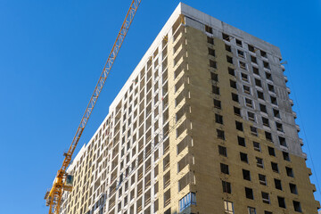 Exterior passive house wall heat insulation with mineral wool. Frame part of metallic tower crane...