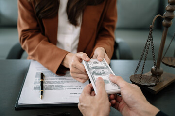 Fototapeta premium Businessman giving bribe money in the envelope to partner in a corruption scam in office.