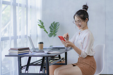 Pretty Asian woman using laptop while sitting at work concentrate on office work as an accountant Startup Business Executive Young female business leaders startup business ideas