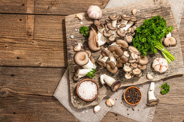 Oyster mushrooms ready for cooking. Fresh parsley, spices, garlic. Trendy hard light, dark shadows